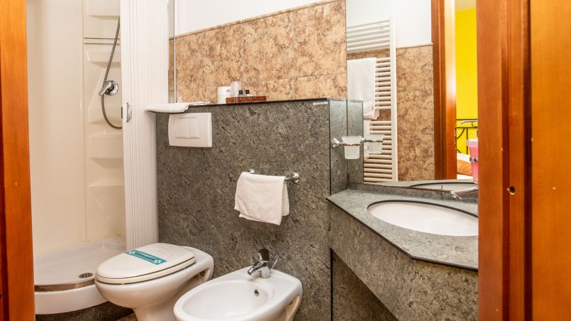 Salle de bains avec cabine de douche, lavabo, toilettes et bidet